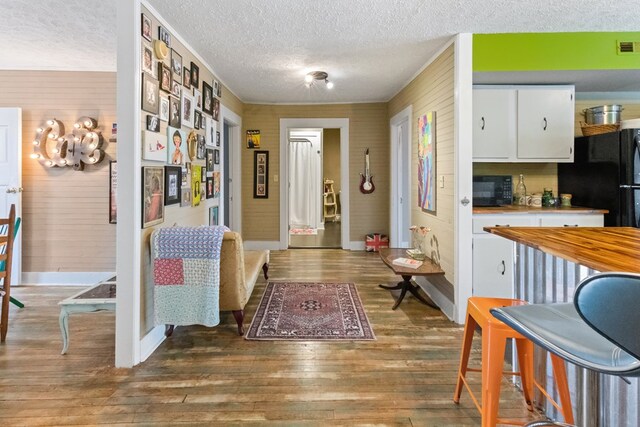 interior space featuring dark wood-style floors, visible vents, baseboards, and a textured ceiling