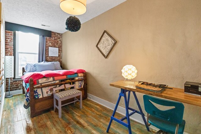 bedroom with visible vents, a textured wall, dark wood-type flooring, a textured ceiling, and baseboards