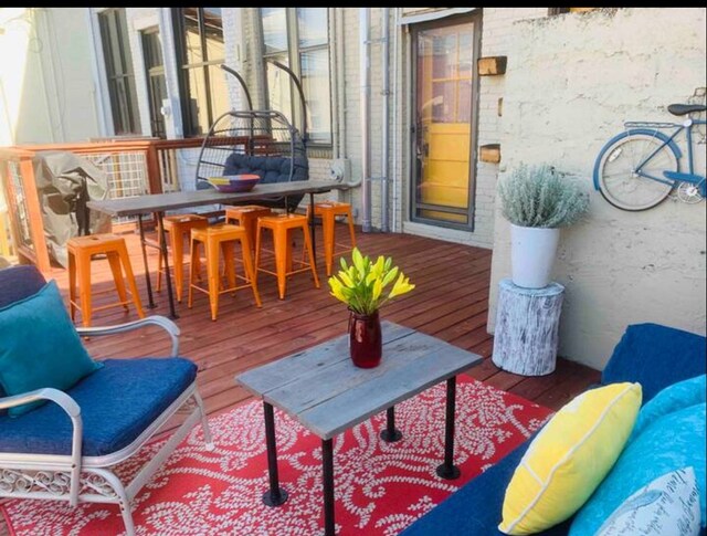 view of wooden balcony featuring outdoor dining space and a wooden deck