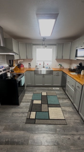 kitchen with gray cabinets, stainless steel microwave, range with electric stovetop, and a sink