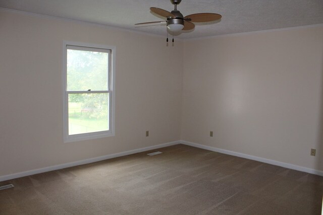 carpeted empty room featuring ornamental molding, baseboards, and a ceiling fan