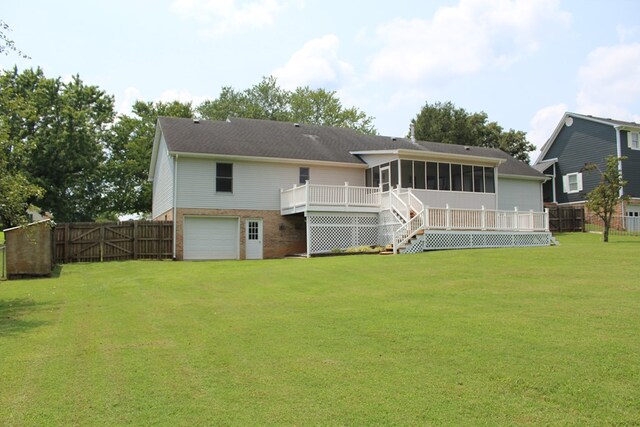 back of property with a deck, a garage, brick siding, fence, and a sunroom