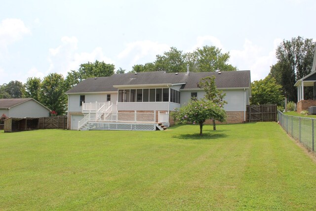 rear view of property with a lawn, stairway, a sunroom, a fenced backyard, and a wooden deck