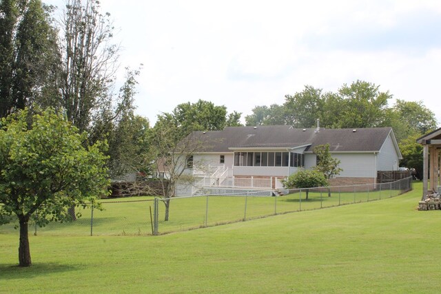 rear view of property with a sunroom, a fenced backyard, and a lawn