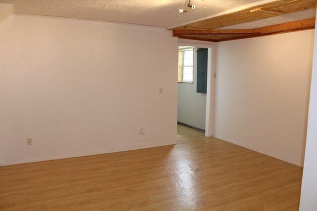 spare room with a textured ceiling and light wood-style floors