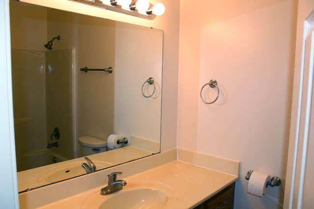 bathroom with bathing tub / shower combination, vanity, and toilet