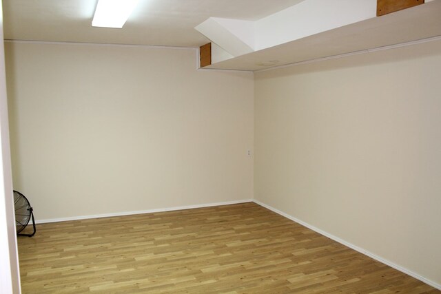 below grade area featuring light wood-style floors and baseboards