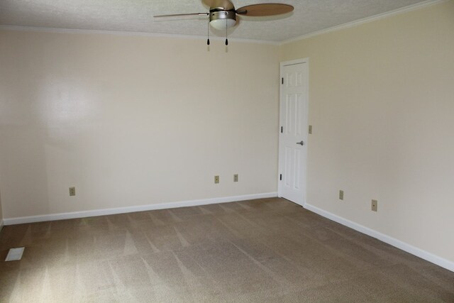 carpeted spare room featuring baseboards, a textured ceiling, a ceiling fan, and crown molding