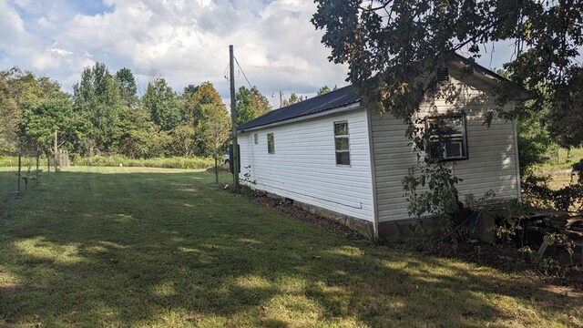 view of property exterior with metal roof and a yard