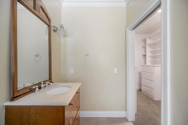 bathroom featuring baseboards, crown molding, and vanity