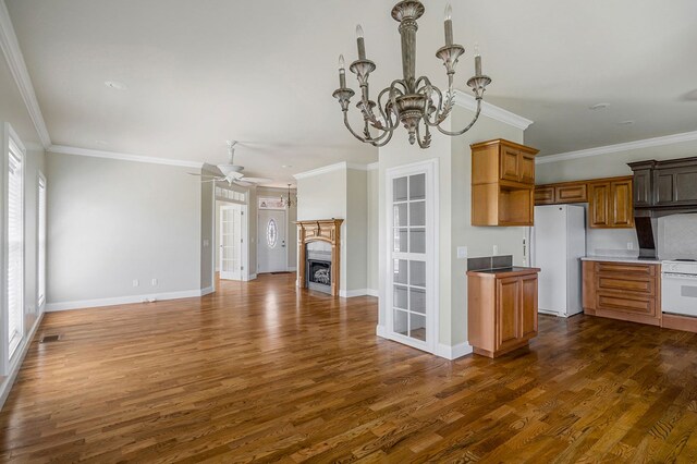 kitchen with dark wood-style floors, crown molding, a fireplace, open floor plan, and white appliances