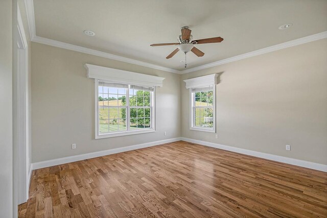 spare room featuring ceiling fan, ornamental molding, wood finished floors, and baseboards