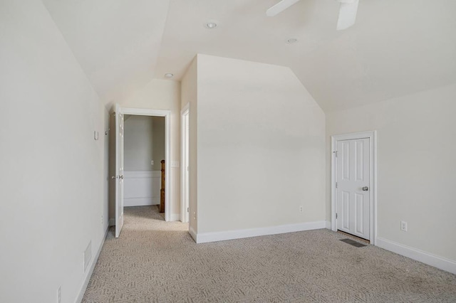 additional living space featuring lofted ceiling, light carpet, baseboards, and a ceiling fan