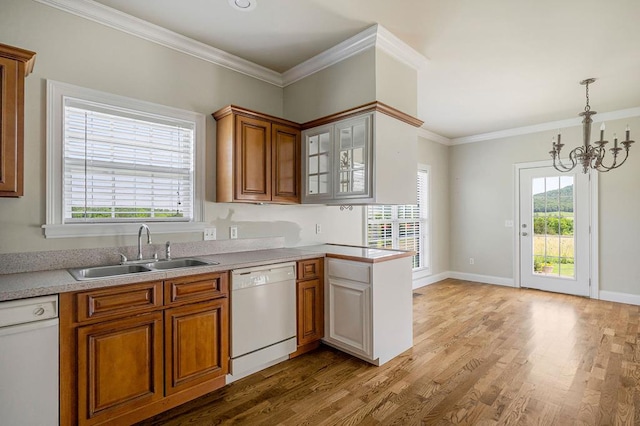 kitchen with wood finished floors, a sink, brown cabinets, dishwasher, and crown molding