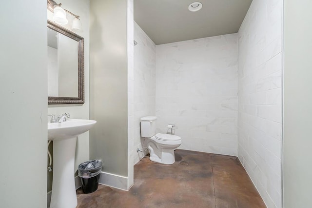 bathroom featuring a sink, toilet, and unfinished concrete floors