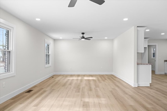 empty room featuring recessed lighting, light wood-style floors, visible vents, and a wealth of natural light