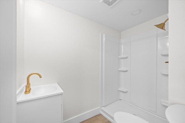 bathroom with visible vents, baseboards, toilet, wood finished floors, and a shower