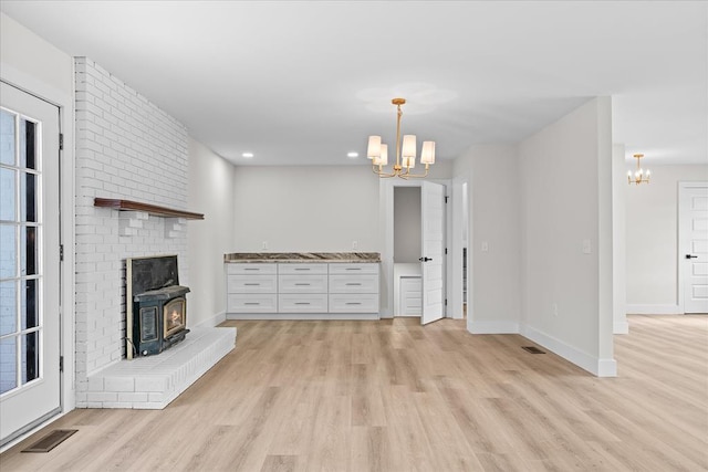 unfurnished living room featuring visible vents, baseboards, light wood-style flooring, recessed lighting, and a notable chandelier