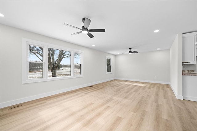 unfurnished living room with recessed lighting, a ceiling fan, light wood-type flooring, and baseboards