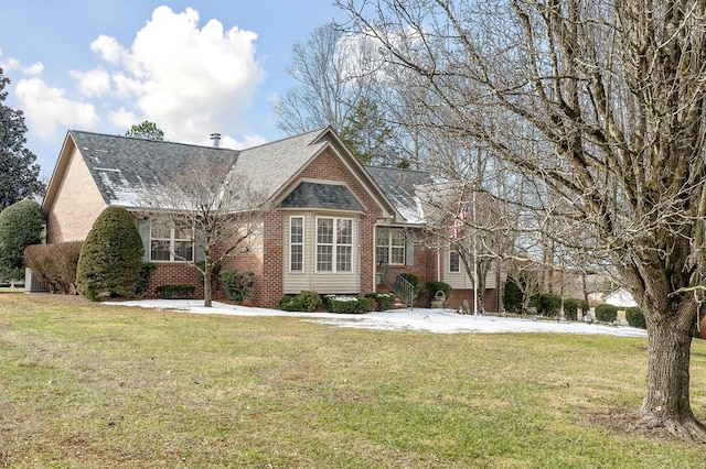 view of front facade with brick siding and a front yard