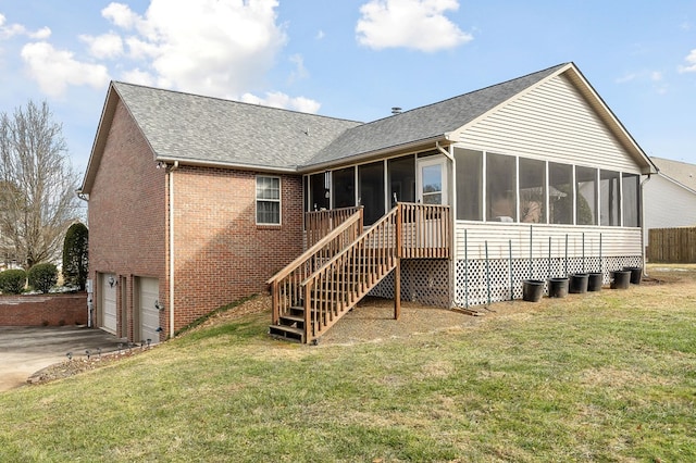 rear view of house featuring a garage, brick siding, a sunroom, concrete driveway, and stairway