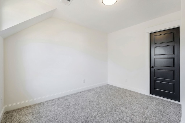 carpeted empty room featuring lofted ceiling and baseboards