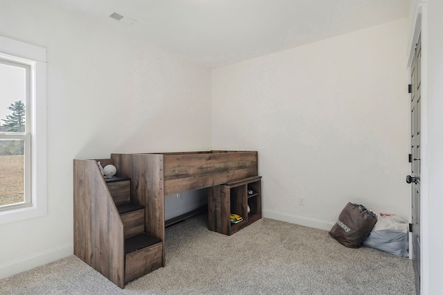 misc room featuring baseboards, visible vents, and light colored carpet