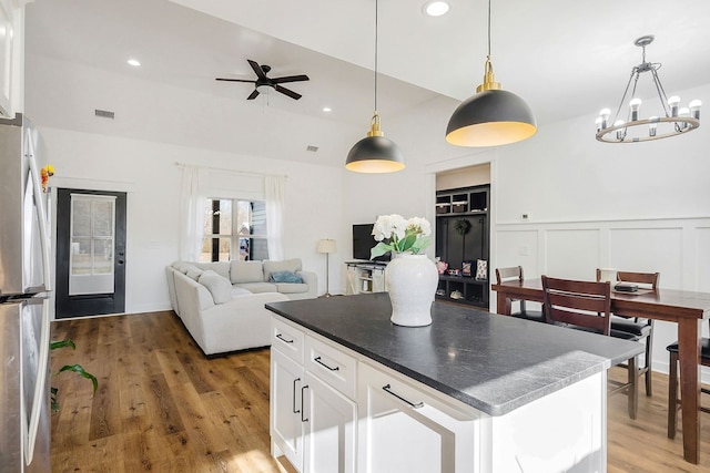 kitchen with dark countertops, pendant lighting, white cabinets, and freestanding refrigerator