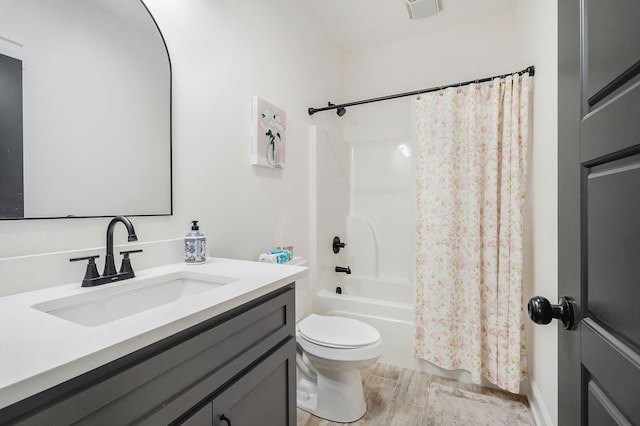 bathroom featuring visible vents, toilet, shower / bath combo with shower curtain, wood tiled floor, and vanity