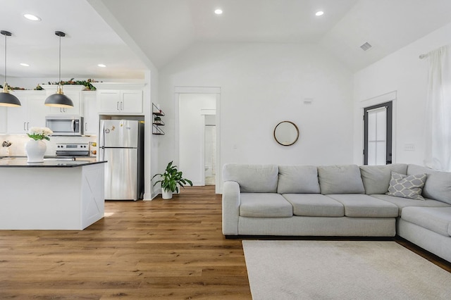 living room featuring high vaulted ceiling, dark wood-style flooring, visible vents, and recessed lighting