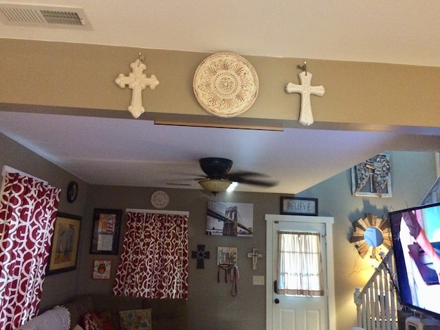 living room with a ceiling fan and visible vents