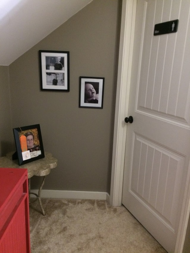 carpeted home office featuring baseboards and vaulted ceiling