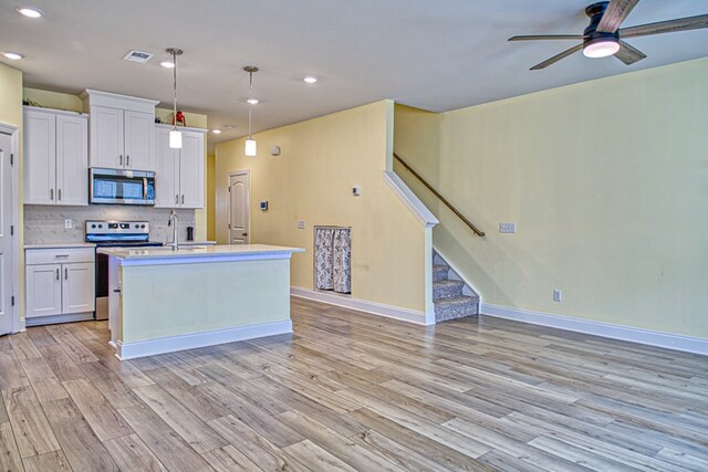 kitchen featuring visible vents, appliances with stainless steel finishes, light countertops, white cabinetry, and pendant lighting