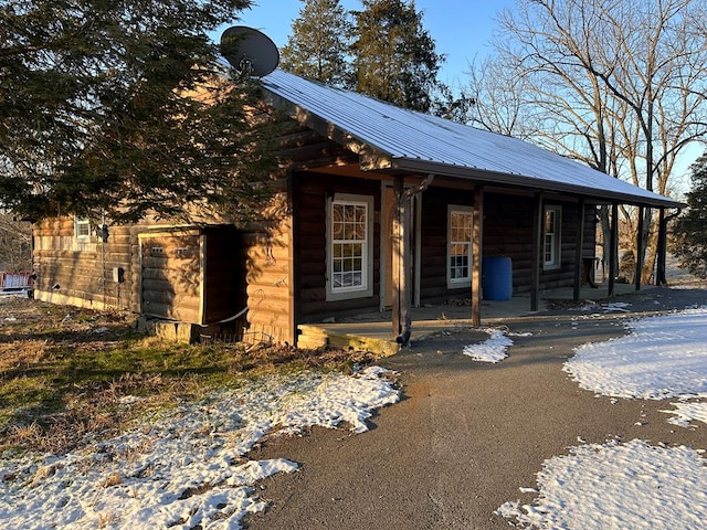 view of front facade with aphalt driveway and metal roof