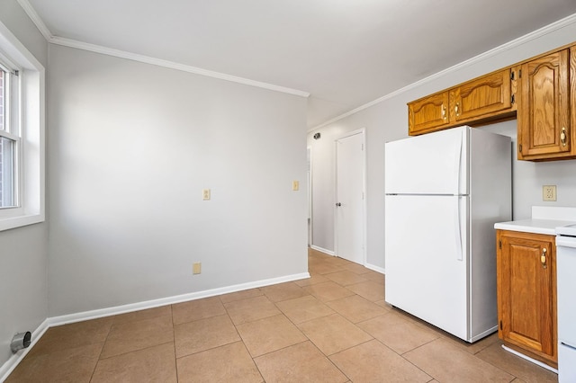 kitchen featuring brown cabinets, ornamental molding, light countertops, and freestanding refrigerator