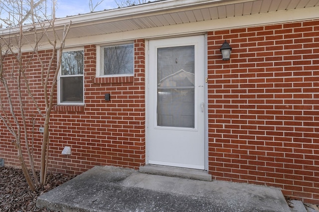 property entrance featuring brick siding