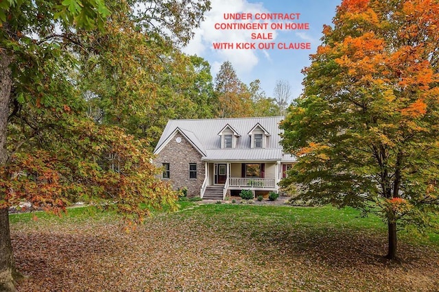 view of front of house featuring metal roof, stone siding, a porch, and a front yard