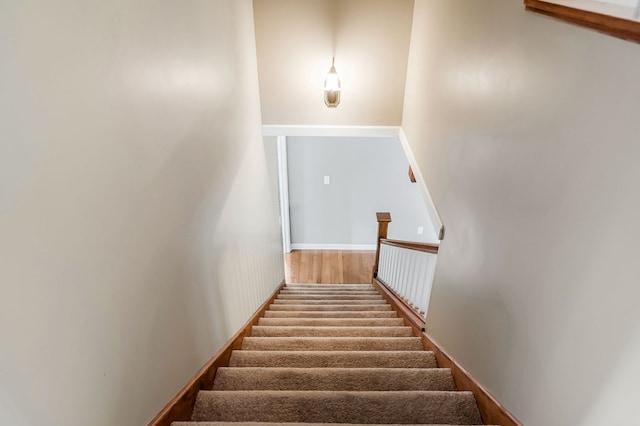 staircase with wood finished floors and baseboards