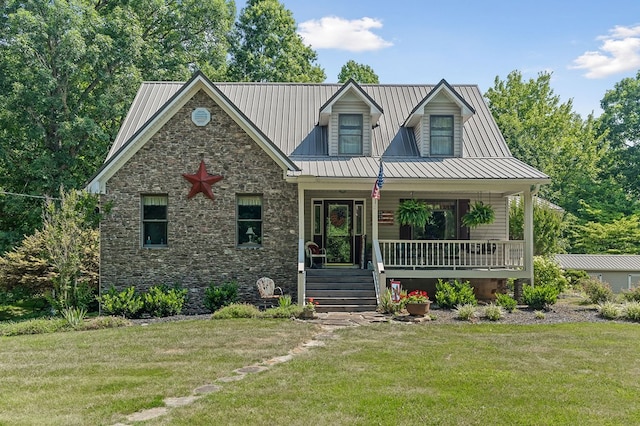 view of front facade with metal roof, a porch, stone siding, a front lawn, and a standing seam roof