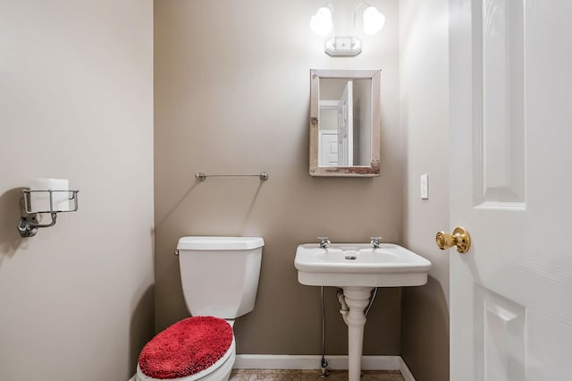 bathroom with toilet and baseboards