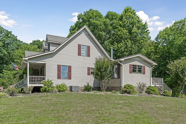 exterior space with central AC, metal roof, a porch, and a lawn