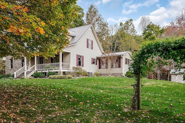 view of property exterior featuring covered porch, a lawn, and central AC unit