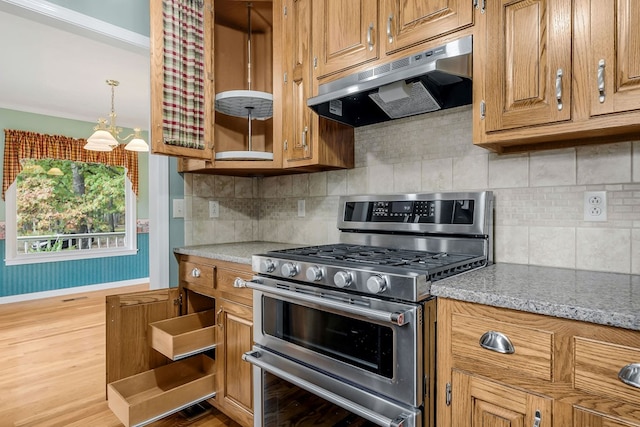 kitchen with range with two ovens, light stone countertops, under cabinet range hood, baseboards, and brown cabinets