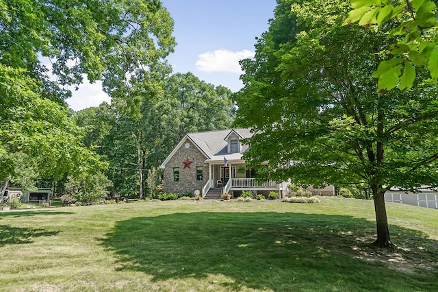 view of front facade featuring covered porch, stone siding, and a front yard