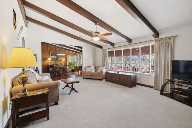 living room featuring a ceiling fan, vaulted ceiling with beams, carpet, and a textured ceiling