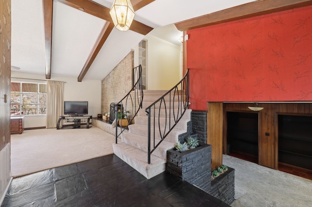 staircase with built in features, carpet floors, and vaulted ceiling with beams