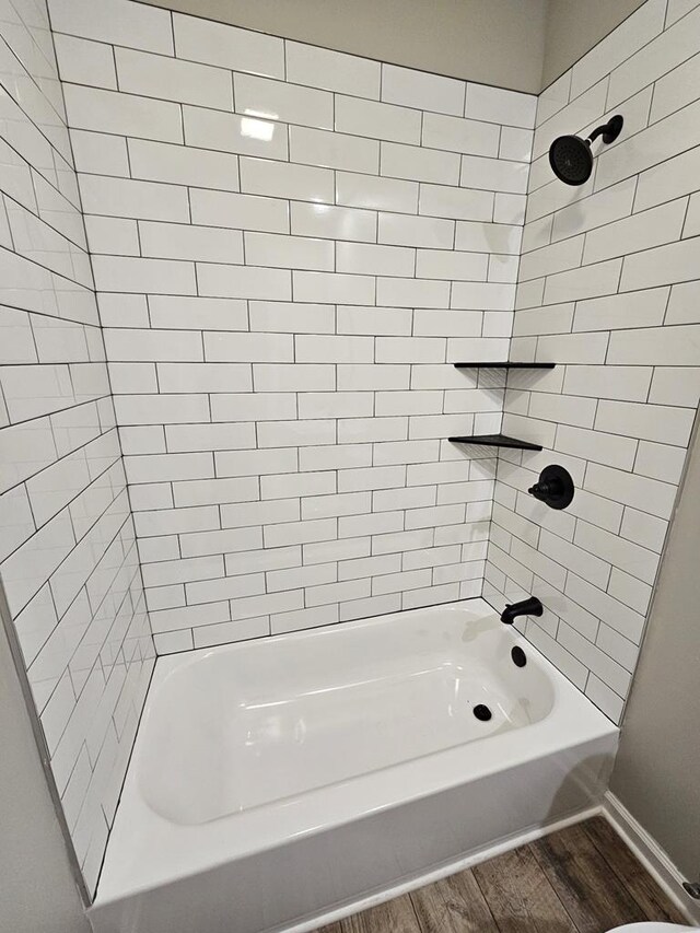 bathroom with bathing tub / shower combination and wood finished floors