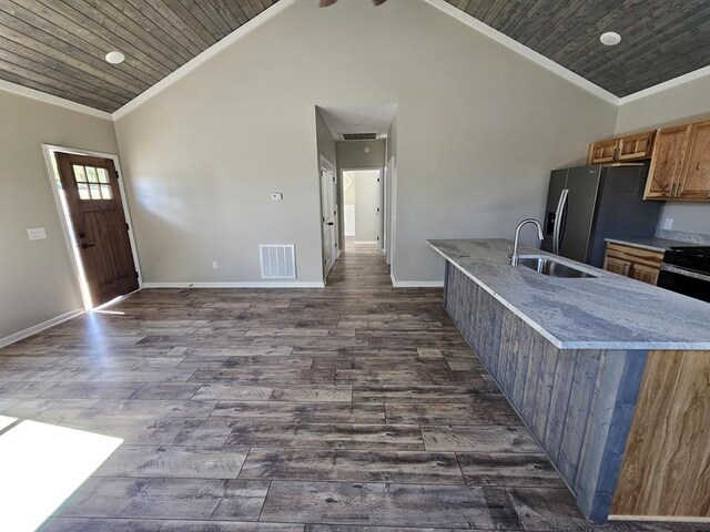 kitchen featuring brown cabinets, crown molding, visible vents, wood ceiling, and a sink