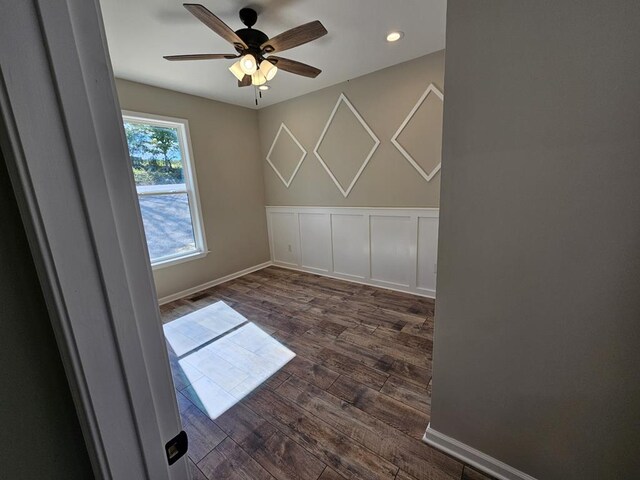 unfurnished room with dark wood finished floors, recessed lighting, a decorative wall, a ceiling fan, and baseboards