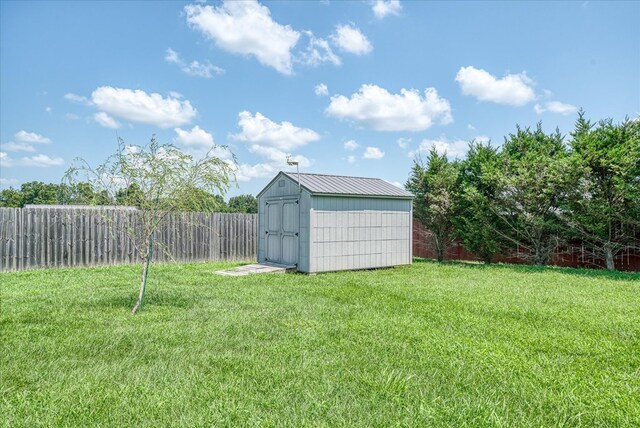 view of yard featuring a shed, an outdoor structure, and fence